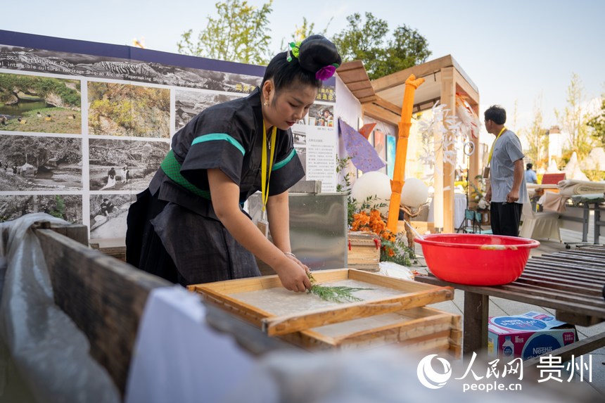 山地生活消费与非遗传承展现场，非遗技艺丹寨古法造纸传承人展示古法造纸技艺。人民网 涂敏摄