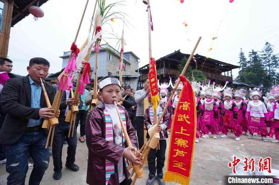 图为榕江县古州镇高武村牛打坪苗寨，身着盛装的苗族同胞吹芦笙跳芦笙舞。韦贵金 摄