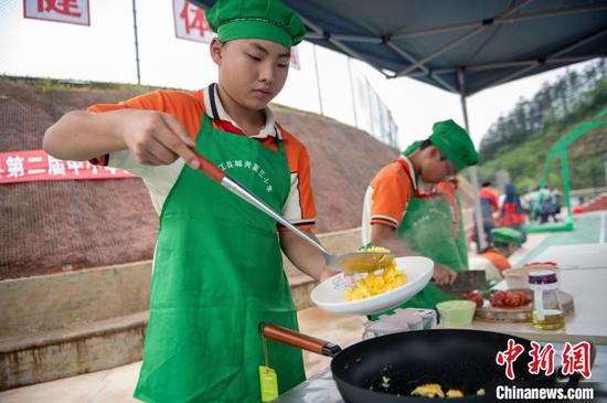 5月9日，在贵州省从江县城关第三小学，参赛选手在合作炒制西红柿炒蛋。吴德军 摄