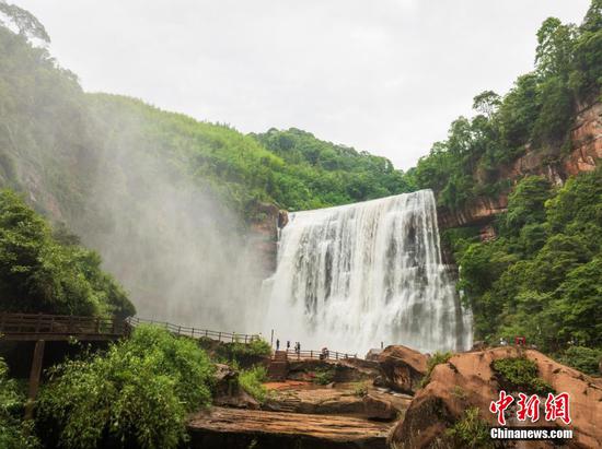 5月27日，游客在赤水丹霞旅游区·赤水大瀑布前拍照打卡。